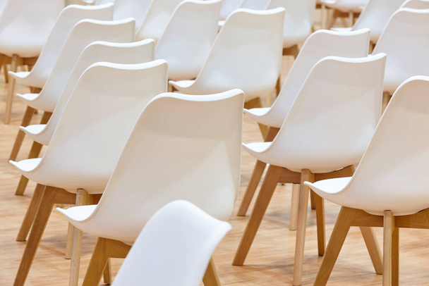 Białe krzesła w sali konferencyjnej. Przestrzeń robocza wewnątrz przedsiębiorstwa - Zdjęcie, obraz