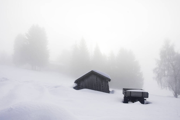 Paisagem foto de uma pequena casa de campo em montanhas durante o tempo nebuloso e temporada de inverno - Foto, Imagem