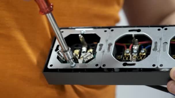 Close-up van een man ontschroeven stopcontact met schroevendraaier om het te installeren. - Video