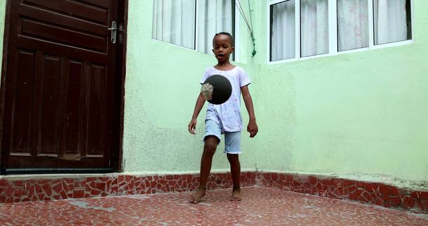 Afrikaans kind spelen met bal, zwart jong jongen kid speelt sport door zichzelf - Foto, afbeelding