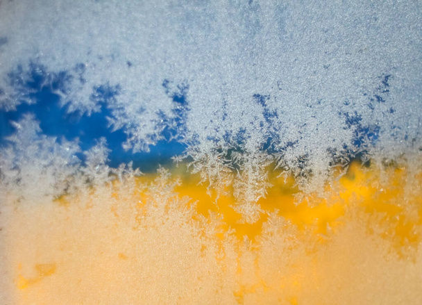Imagen borrosa Bandera de Ucrania, Hoarfrost sobre vidrio, heladas, frío. Fondo amarillo-azul. Símbolo, cartel, bandera de la bandera nacional. - Foto, Imagen