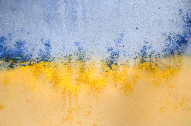 Imagen borrosa Bandera de Ucrania, Hoarfrost sobre vidrio, heladas, frío. Fondo amarillo-azul. Símbolo, cartel, bandera de la bandera nacional. - Foto, Imagen