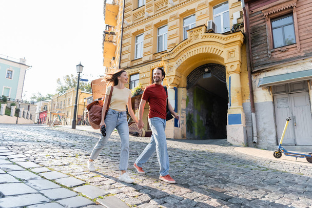 Χαρούμενοι τουρίστες με χάρτη και κυάλια περπάτημα σε αστικό δρόμο στην πόλη  - Φωτογραφία, εικόνα