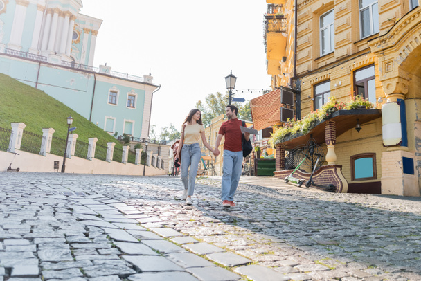 Turistas con mapa y binoculares caminando por la calle de la ciudad  - Foto, Imagen