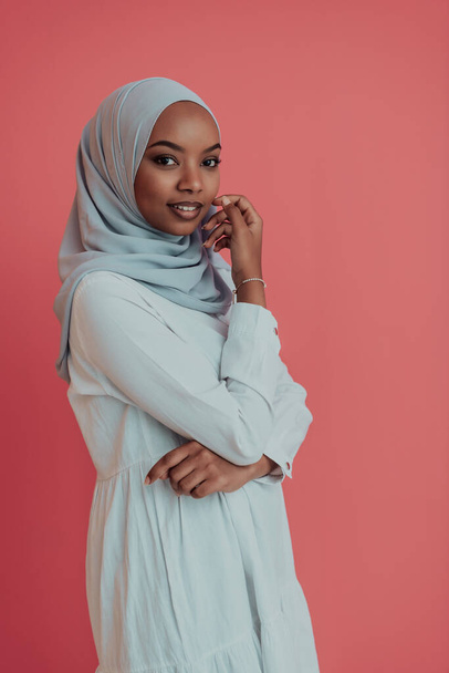 Portrait of young modern muslim afro beauty wearing traditional islamic clothes on plastic pink background. Selective focus  - Foto, Imagem