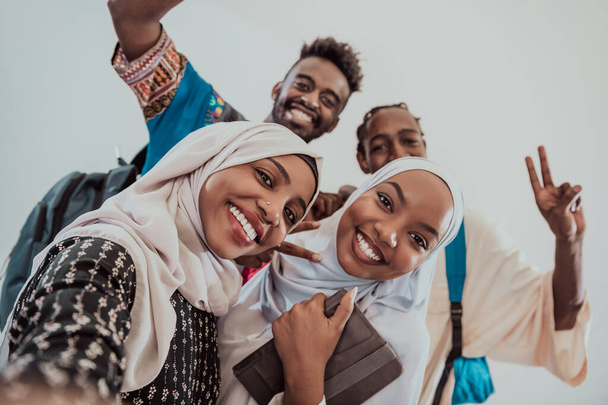 A group of multiethnic students take a selfie with a smartphone on a white background. Selective focus  - Foto, Bild