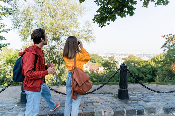Туристична карта біля дівчини з рюкзаком і біноклями на міській вулиці
  - Фото, зображення