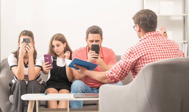 psycholoog geven gezinstherapie voor telefoon verslaafde vader moeder en dochter meisje, afhankelijkheid - Foto, afbeelding