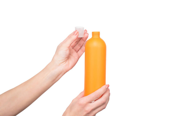 female hands hold sunblock bottle with copy space - Fotó, kép