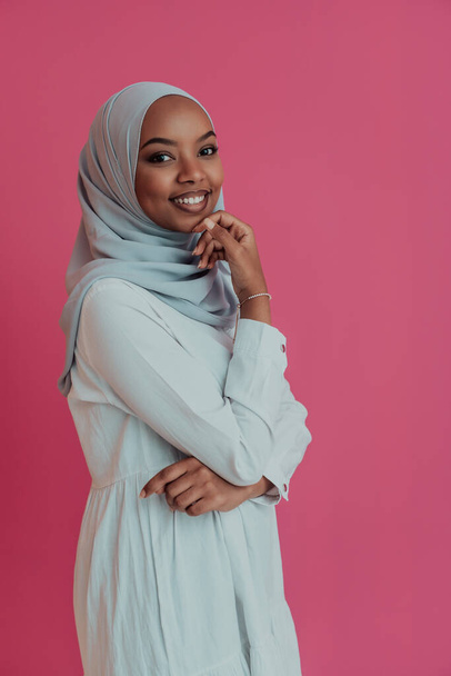 Portrait of young modern muslim afro beauty wearing traditional islamic clothes on plastic pink background. Selective focus  - Zdjęcie, obraz