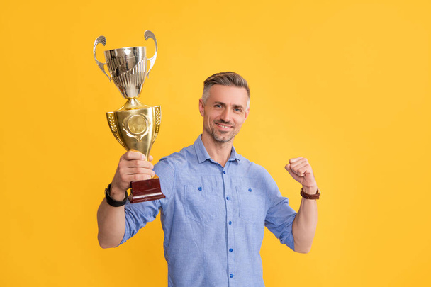 счастливый успешный человек держать золотой кубок, мотивация - Фото, изображение