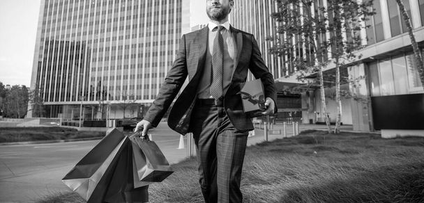 entrepreneur carry birthday gift. guy hold shopping bags. mens day. cropped businessperson - Fotografie, Obrázek