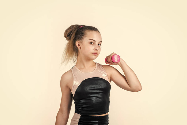 teen girl training triceps muscles with dumbbell, power - Φωτογραφία, εικόνα