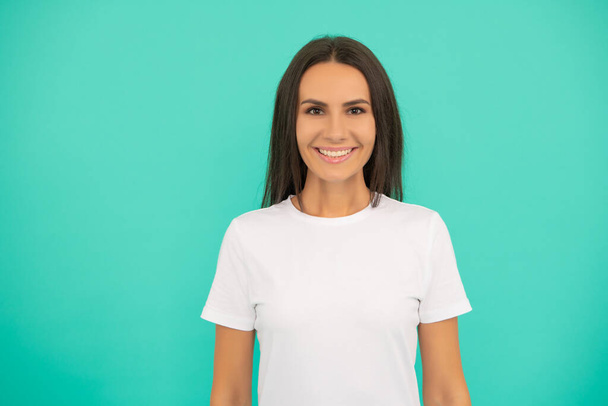 happy young woman in white shirt on blue background - Photo, image