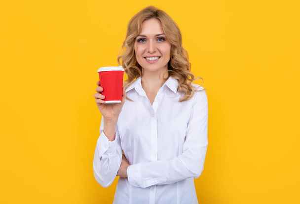 mujer rubia sonriente con taza de café sobre fondo amarillo - Foto, imagen