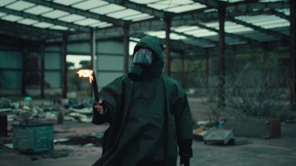 Soldat mit Gasmaske in einem zerstörten Gebäude durch Krieg mit Fackel - Filmmaterial, Video