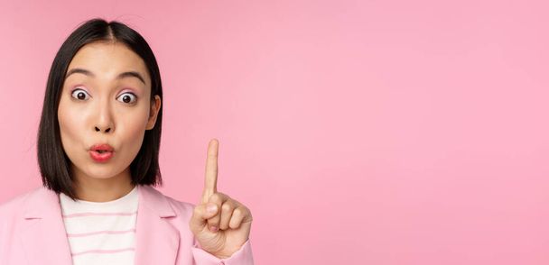 Close up retrato de empresária levantando o dedo, sugerindo, tem uma ideia ou solução, de pé sobre fundo rosa - Foto, Imagem