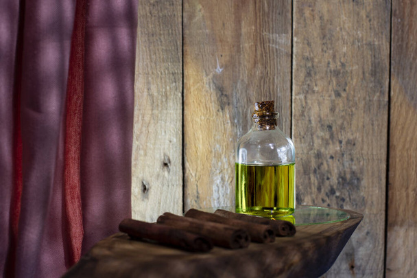 Botella de aceite de canela y palitos de canela - Foto, Imagen