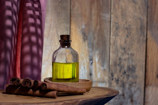Láhev skořicového oleje a skořicových tyčinek - Fotografie, Obrázek