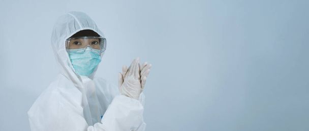 Doctor in PPE suit wearing white medical rubber gloves and clear goggles and green N95 face mask to protect pandemic Coronavirus. gesture make hand sign. Represent victory win over virus. Isolated. - Foto, imagen