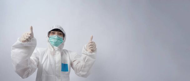 Dokter in PPE-pak draagt witte medische rubberen handschoenen en een heldere bril en groene N95 gezichtsmasker om een pandemie Coronavirus te beschermen. gebaar maak handgebaar. De overwinning op het virus vertegenwoordigen. geïsoleerd. - Foto, afbeelding