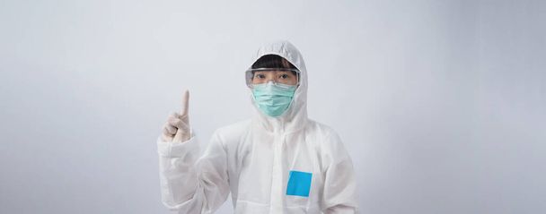 Doctor in PPE suit wearing white medical rubber gloves and clear goggles and green N95 face mask to protect pandemic Coronavirus. gesture make hand sign. Represent victory win over virus. Isolated. - Photo, Image