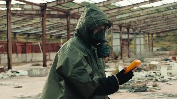 Homem com máscara de radiação e contador de geiger verifica um local nuclear - Filmagem, Vídeo