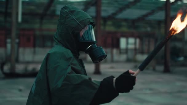 Gaz maskeli bir asker, meşaleyle yıkılan bir binada. - Video, Çekim