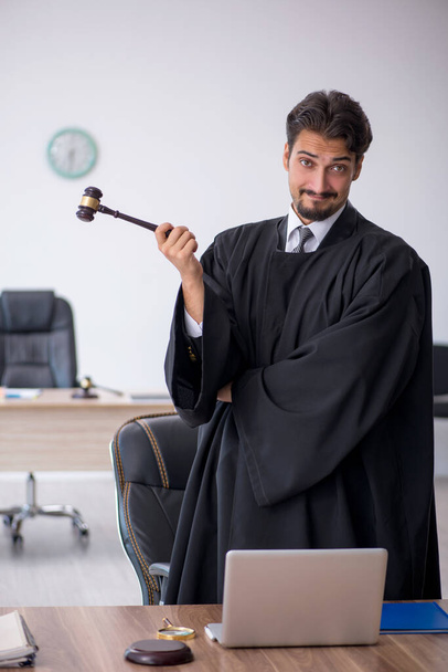 Jonge mannelijke rechter werkt in het gerechtsgebouw - Foto, afbeelding