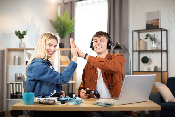 boy and girl, giving high five each other while celebrating success after playing game - Foto, Imagem
