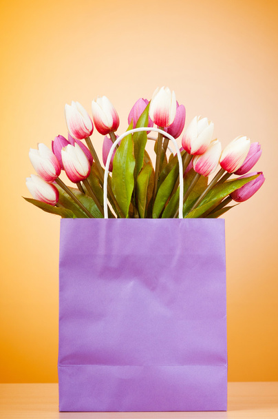 Tulpen in de zak tegen achtergrond met kleurovergang - Foto, afbeelding