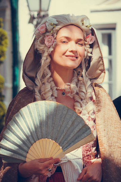 Πορτρέτο της ξανθιάς γυναίκας ντυμένη με ιστορικά μπαρόκ ρούχα με παλιό χτένισμα μόδας, σε εξωτερικούς χώρους. Πολυτελές μεσαιωνικό φόρεμα - Φωτογραφία, εικόνα