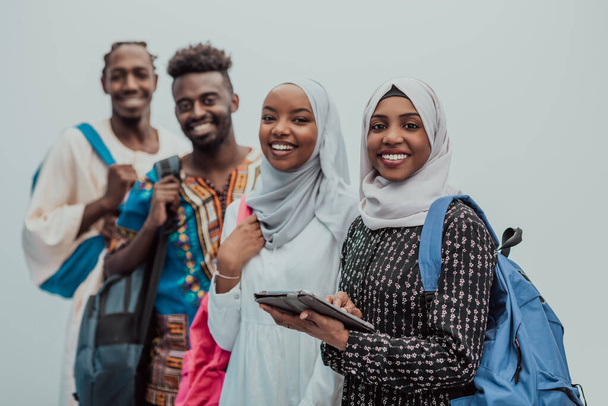 Photo of a group of happy african students talking and meeting together working on homework girls wearing traditional Sudanese Muslim hijab - 写真・画像