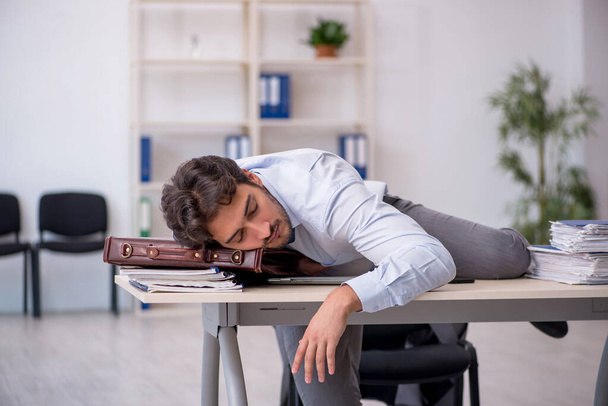 Junge männliche Angestellte in verschlafenem Konzept - Foto, Bild