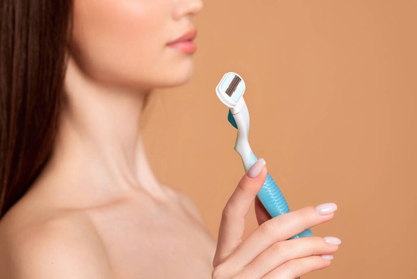 attractive girl holding in hand razor shaver blade i - Фото, изображение