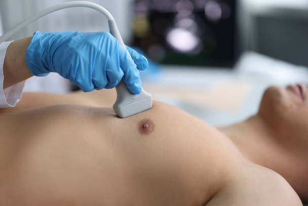Doctor conducts medical diagnosis of ultrasound of heart of man - Φωτογραφία, εικόνα