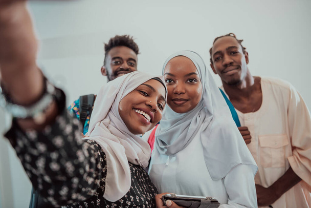 A group of multiethnic students take a selfie with a smartphone on a white background. Selective focus  - Fotó, kép