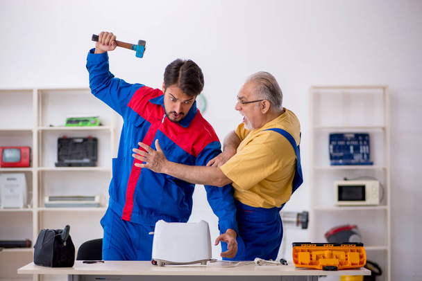 Two male repairmen working at workshop - Photo, Image