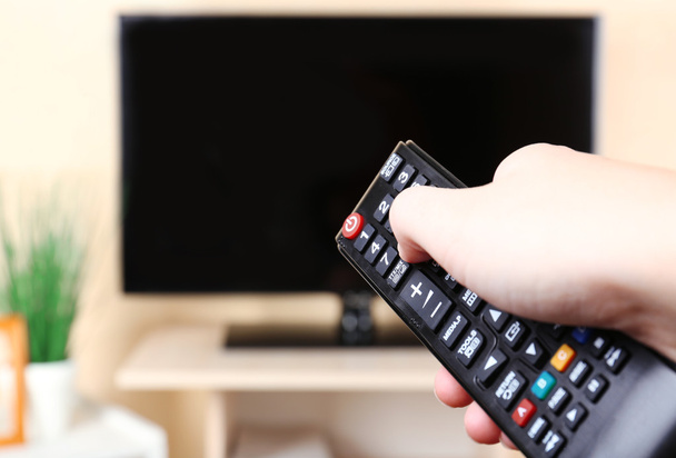 Watching TV and using remote controller - Photo, Image