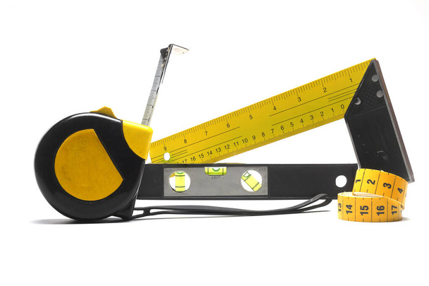 Жовта вимірювальна стрічка для рулетки або лінійки інструментів. Стрічка вимірює шаблон в сантиметрах. Набір вимірювачів стрічок ізольовано на чорному тлі
. - Фото, зображення