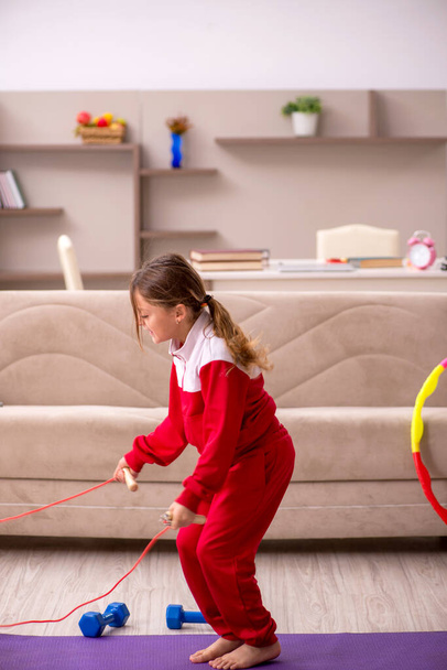 Mladá holčička dělá sportovní cvičení doma - Fotografie, Obrázek