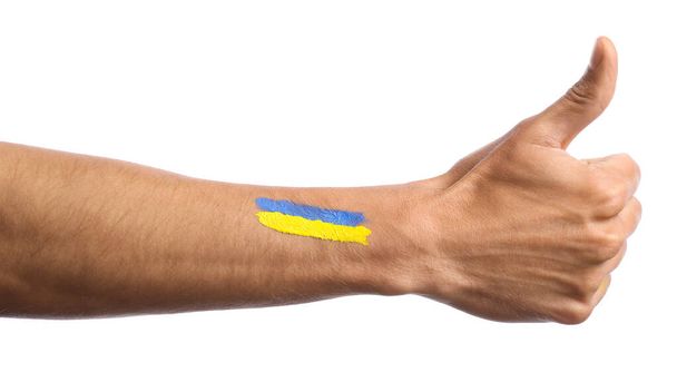 Main masculine avec drapeau ukrainien peint montrant geste pouce vers le haut sur fond blanc - Photo, image