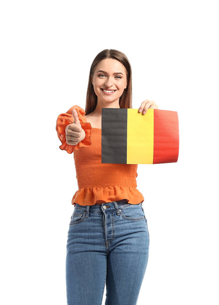 Młoda kobieta z flagą Belgii pokazuje kciuk do góry na białym tle - Zdjęcie, obraz