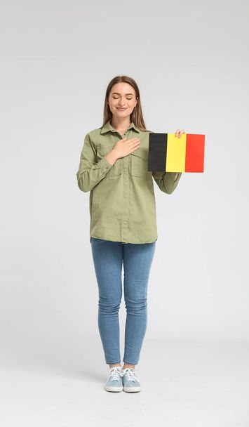 Młoda kobieta z flagą Belgii na jasnym tle - Zdjęcie, obraz
