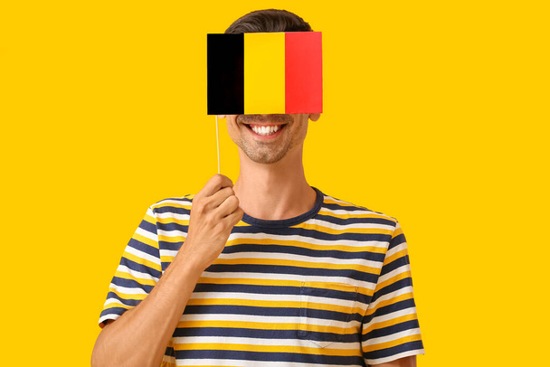 Młody człowiek z flagą Belgii na tle koloru - Zdjęcie, obraz