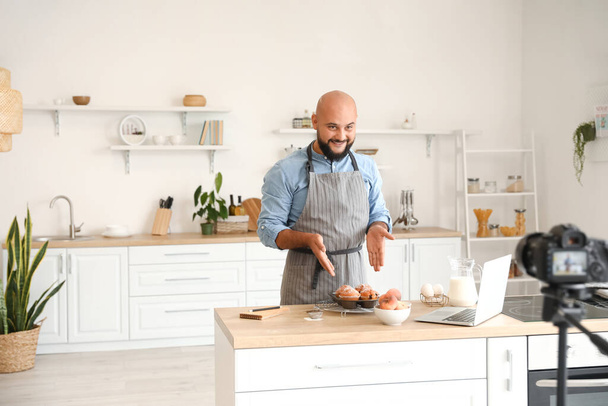 Chef masculino con sabrosas magdalenas de melocotón en la cocina - Foto, imagen