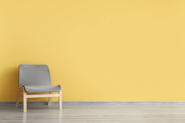Mukava nojatuoli lähellä keltaista seinää - Valokuva, kuva