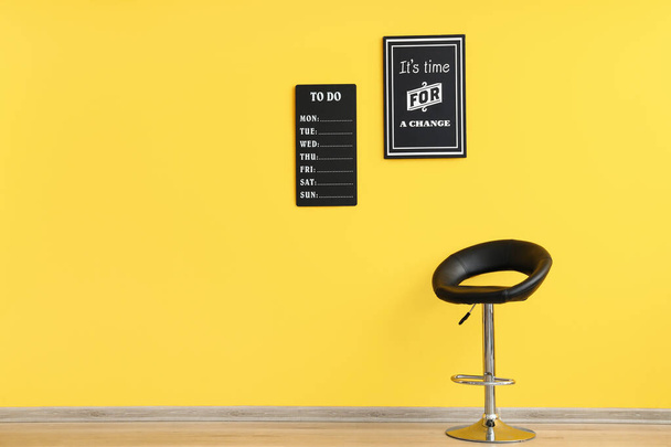 Lista de tarefas, cartaz elegante e cadeira confortável perto da parede amarela - Foto, Imagem