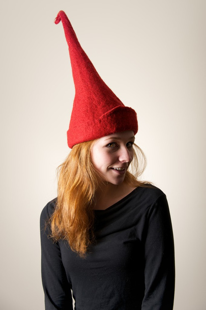 Pelirroja en sombrero rojo puntiagudo girando cabeza
 - Foto, imagen
