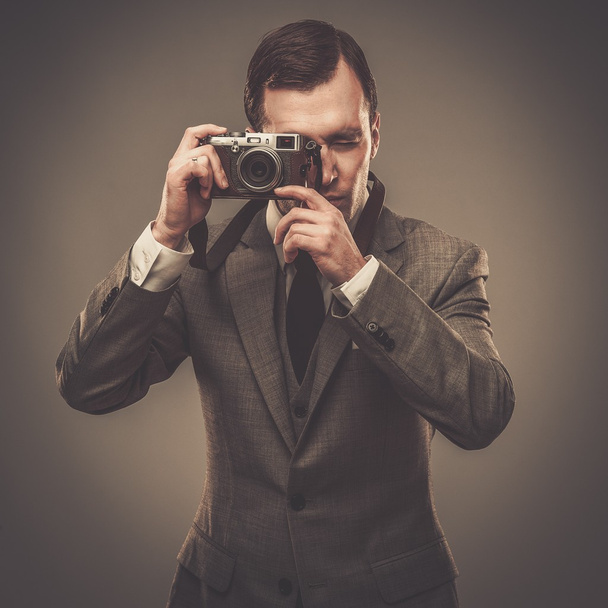 Well-dressed man with a retro camera - Photo, Image